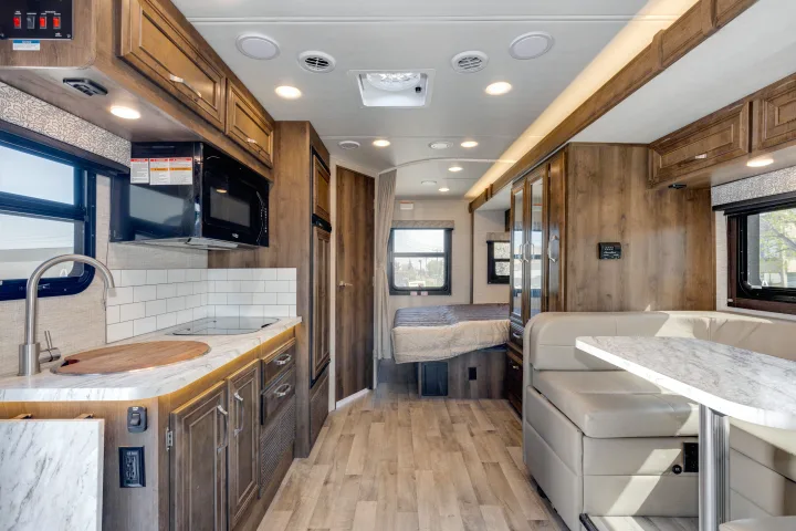 Spacious RV rental interior with full kitchen, dining area, and cozy bedroom. Perfect for camper adventures.. Jayco Melbourne 2022