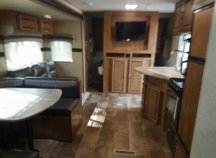 Spacious RV rental interior featuring a cozy living area, modern kitchen, and entertainment center.. Crossroads Zinger 2017