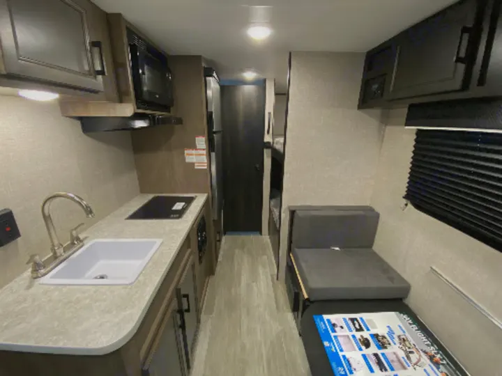 Well-equipped RV rental interior showcasing a full kitchen, convertible dinette, and bunk beds. Ideal for travel adventures.. Jayco Jay Flight SLX 2022