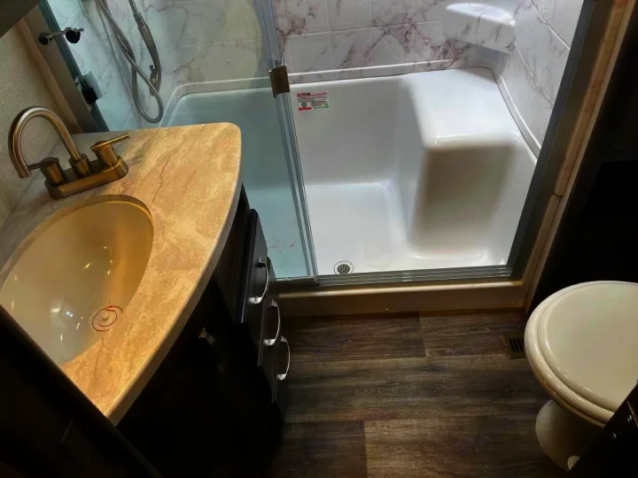 RV rental bathroom features: compact sink vanity, shower/tub, and toilet. Clean, functional interior for your trip.. Keystone Cougar 2022
