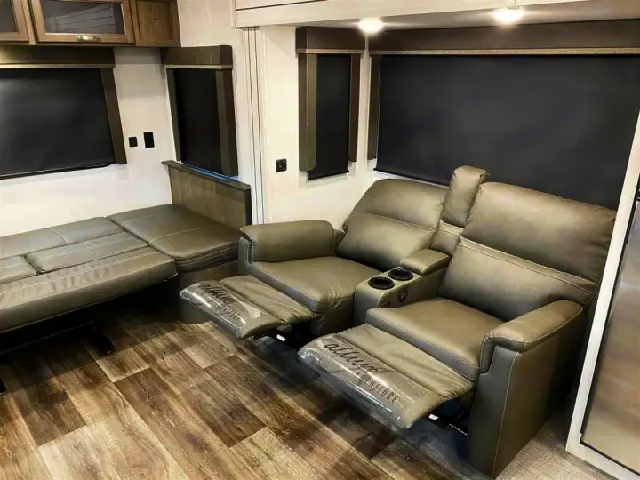 Comfortable RV rental interior featuring recliners, a fold-out bed, and modern living amenities for travel.. Keystone Cougar 2022