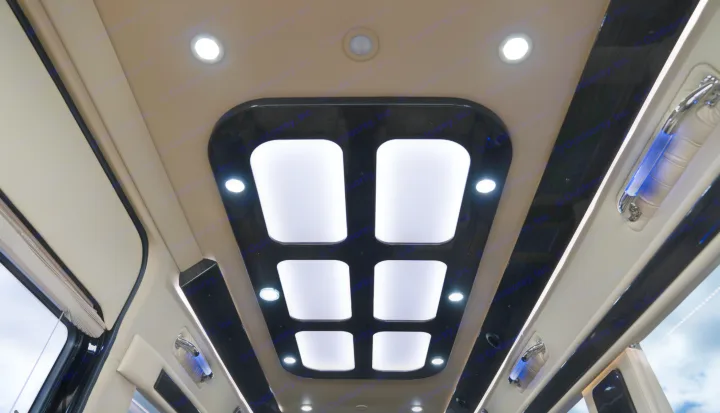 RV rental interior: Modern ceiling with bright panel and spot lighting, plus blue accent grab handles.. Midwest Automotive Designs Daycruiser 2019