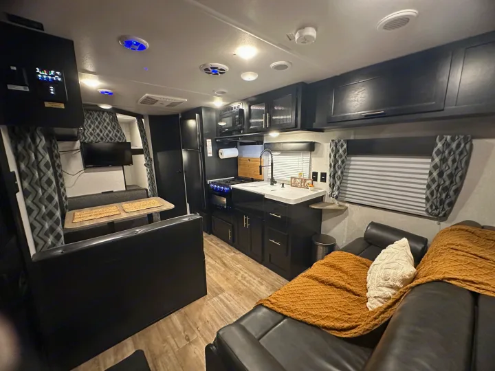 Cozy RV rental interior with a sleek kitchen, dinette, and lounge area, perfect for your next adventure.. Forest River Cherokee Grey Wolf Special Edition 2022