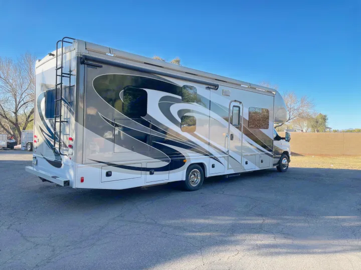 Experience freedom with this beautiful RV rental. A large motorhome, visible parked on asphalt under clear skies.. Jamboree Jamboree Motorhome 2017