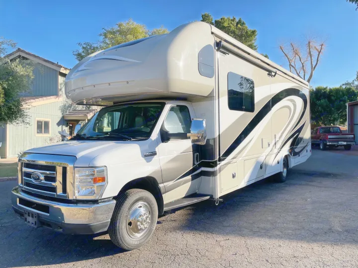 Spacious white and tan Class C RV rental parked outdoors, ideal for your next travel adventure.. Jamboree Jamboree Motorhome 2017