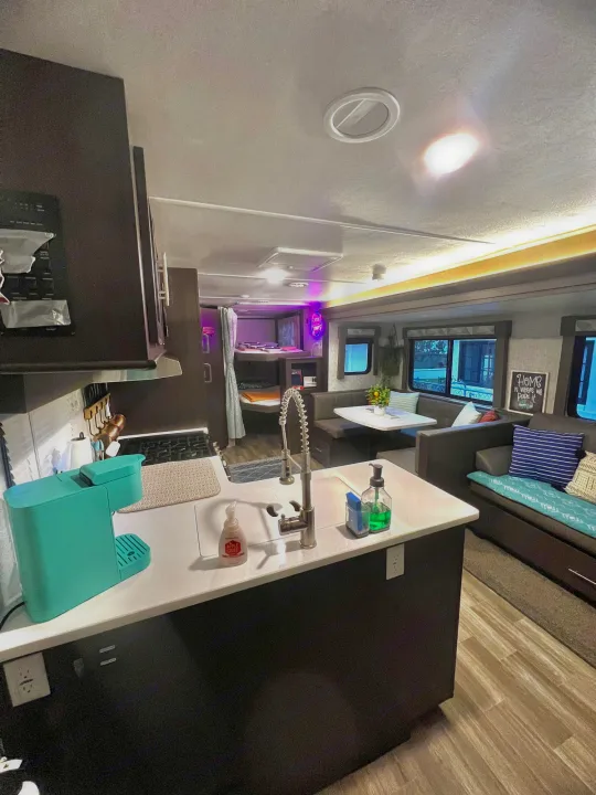 Explore this modern RV rental's inviting interior: fully equipped kitchen, dinette, cozy lounge, and bunk beds.. Forest River Wildwood 2020