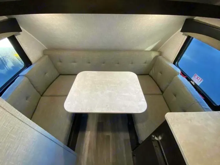 RV rental: Spacious U-shaped dinette with light grey cushions and a table, perfect for meals and relaxing in this travel trailer.. Braxton Creek Bushwhacker Plus 2021