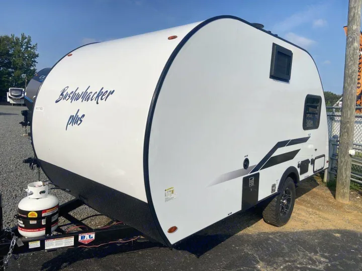 White Bushwhacker Plus teardrop travel trailer, ideal for an RV rental. Features a propane tank & off-road tires.. Braxton Creek Bushwhacker Plus 2021