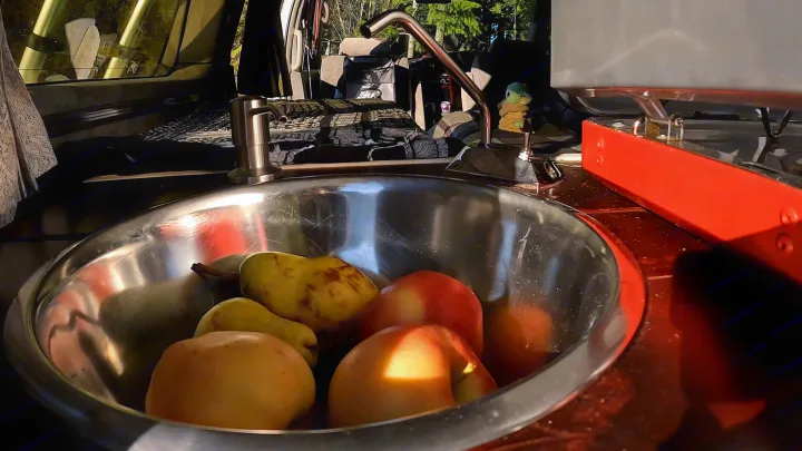RV rental kitchen: Fresh apples & pears in the sink, with a faucet & stove. Ready for camper van adventures.. nissan elgrand 1997