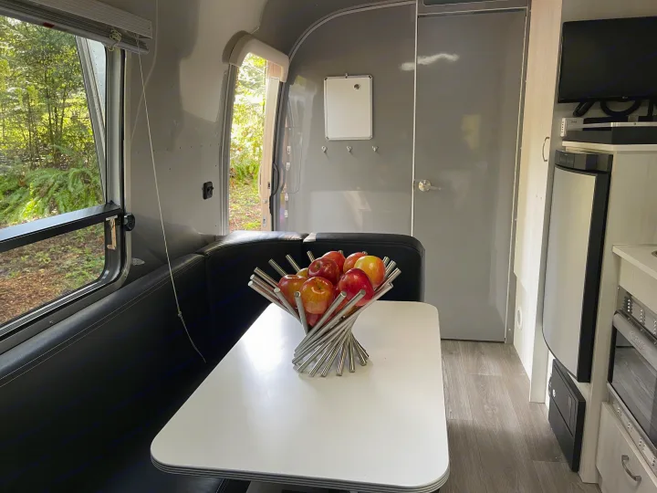 Cozy RV rental interior: dining area with a view, kitchen, and ample living space for comfortable travel.. Airstream Sport 2019