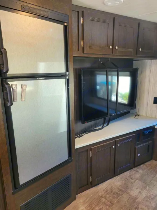 RV rental interior: Dometic fridge, counter, cabinets, and TV secured for travel.. Heartland RVs Pioneer 2020