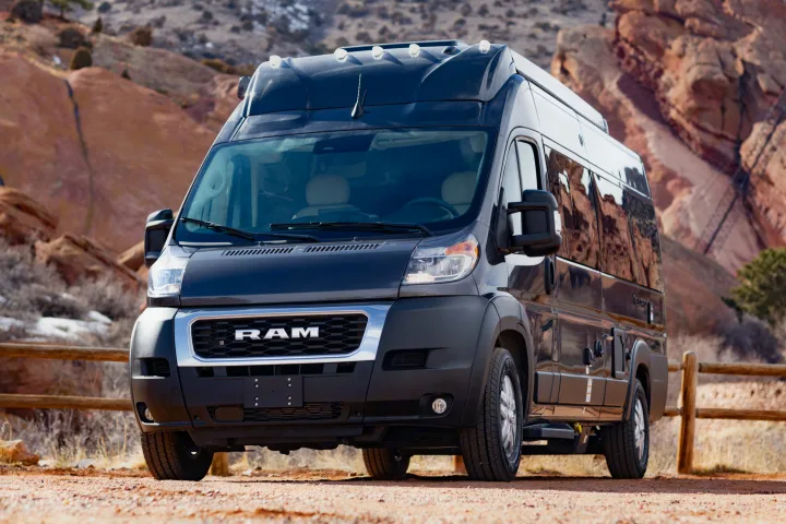 A black Ram ProMaster camper van, ideal for your next RV rental adventure. Parked against stunning red rock scenery.. Thor Tellaro 2023