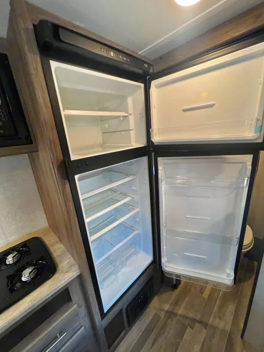 RV rental interior features a clean, open top-mount refrigerator and freezer, ready for your trip.. Crossroads Zinger Lite 2022
