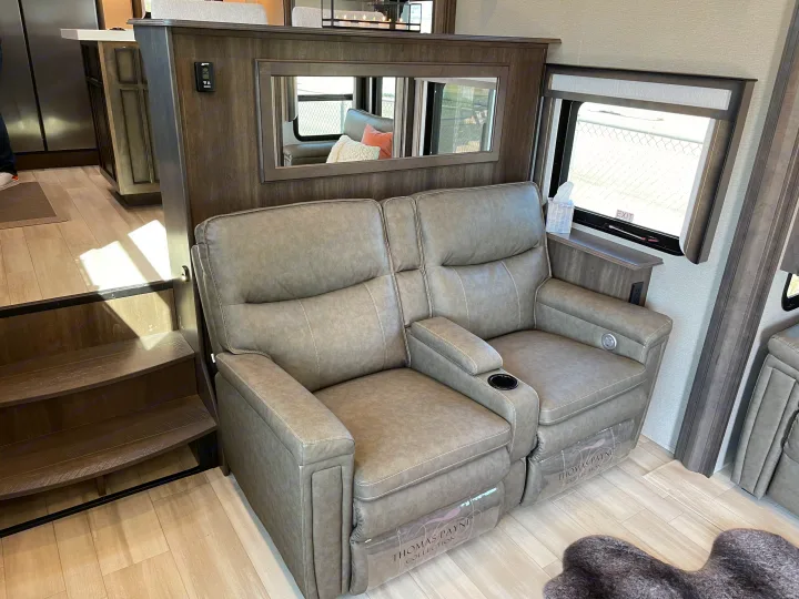 Comfortable grey recliners, part of a cozy RV rental living area with steps and built-in features.. Grand Design Solitude 2022