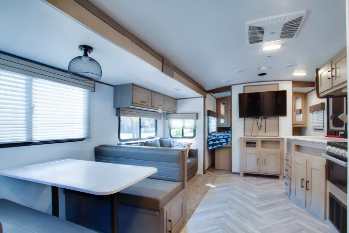 Modern RV rental interior: dining area, living room with sofa, and fully equipped kitchen for comfortable adventures.. Cruiser Rv Corp Shadow Cruiser 2021