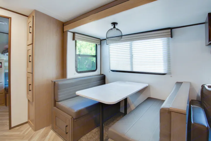 This RV rental features a comfortable dinette with cushioned benches, a light table, and a large window.. Cruiser Rv Corp Shadow Cruiser 2021