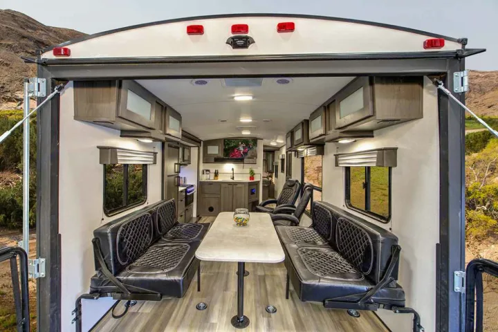 Spacious toy hauler RV rental interior: kitchen, seating, and open rear patio with outdoor views.. Cruiser Rv Corp MPG 2700TH 2022