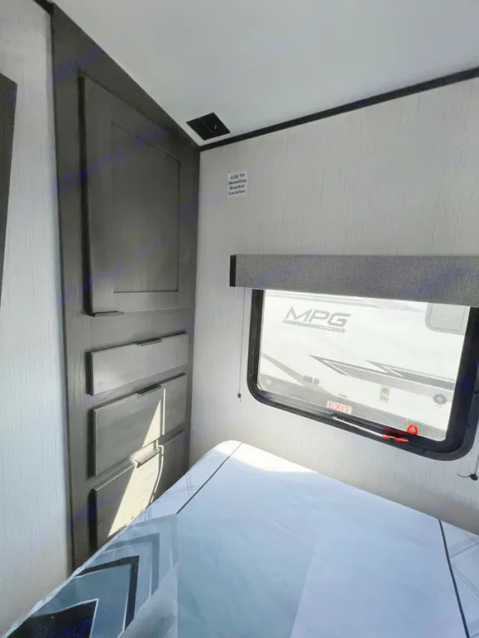 This RV rental bedroom features a comfy bed, built-in storage, and a window. A designated TV mount area is visible.. Cruiser Rv Corp MPG 2700TH 2022