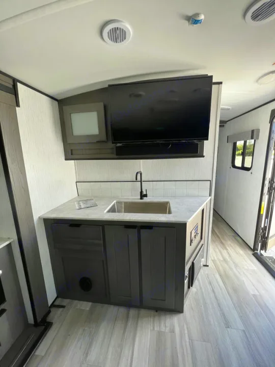 RV rental: Stylish galley with sink, TV, cabinets, and light wood-look floor. Compact & functional.. Cruiser Rv Corp MPG 2700TH 2022