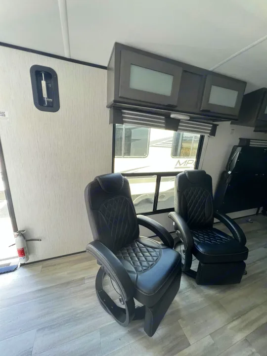 RV rental interior featuring two black comfortable chairs, overhead cabinets, and light wood-look flooring.. Cruiser Rv Corp MPG 2700TH 2022