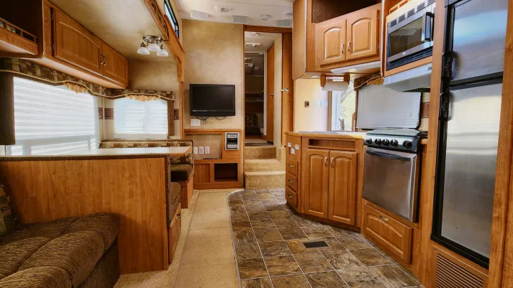 Bright rv rental interior. Features a complete kitchen, dining booth, sofa, and comfortable living space.. Forest River Wildcat 2008