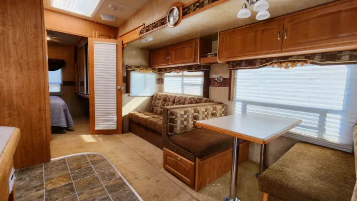 Comfortable RV rental interior with dinette, sofa, and a connecting bedroom area.. Forest River Wildcat 2008