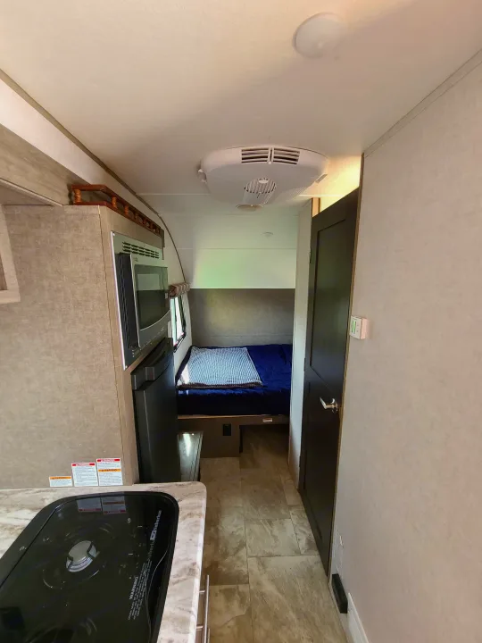 Cozy RV rental interior featuring a compact kitchen, comfortable bed, and accessible bathroom, perfect for travel.. Forest River R-Pod 2018