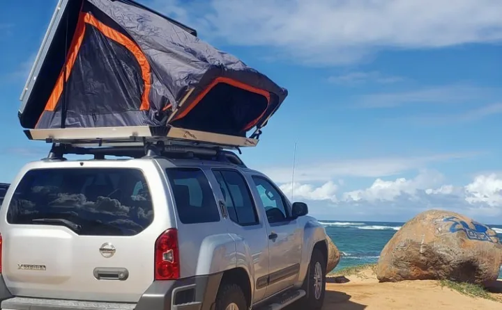 This unique RV rental, a silver SUV with a rooftop tent, offers beachfront camping. Explore outdoor adventures!. NISSAN XTERRA 2014