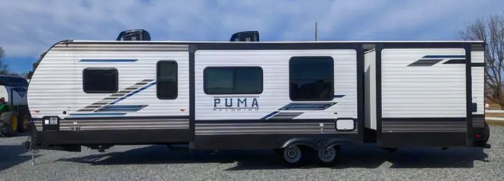 Side view of a white Puma Palomino travel trailer RV, featuring multiple slide-outs, ideal for rv rental.. Forest River Palomino Puma 2022