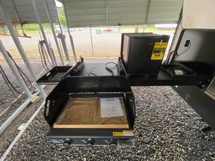 This RV rental features a convenient outdoor kitchen setup with a grill, mini-fridge, and sink for camping adventures.. Forest River Palomino Puma 2022