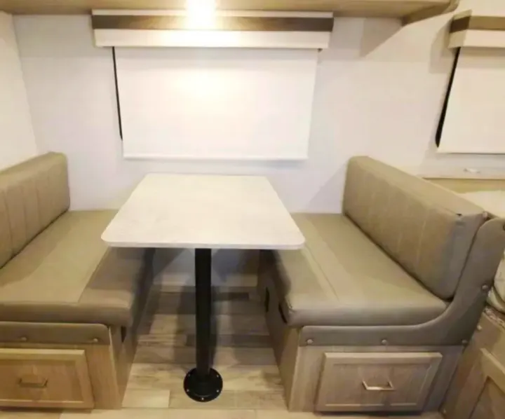 RV rental interior: A bright dinette with a light table, beige booth seating with storage, and white blinds.. Forest River Geo Pro 19BH (bunk house) 2023