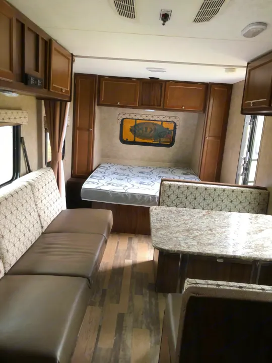 Inside an rv rental: inviting living space with sofa, bed, dinette, and ample storage cabinets.. Forest River Viking 2018