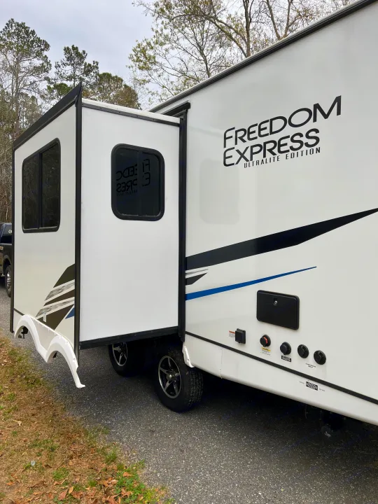 A white Freedom Express Ultralite Edition RV rental with an extended slide-out, ready for your outdoor adventure.. Coachmen Freedom Express 2022