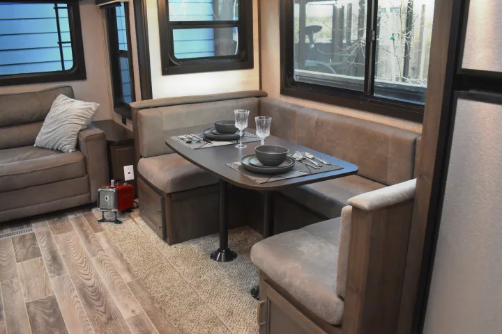 RV rental interior: Features a modern dinette set for two, comfortable sofa, and large windows with outdoor views.. Jayco Jay Flight SLX Rocky Mountain Edition 2021