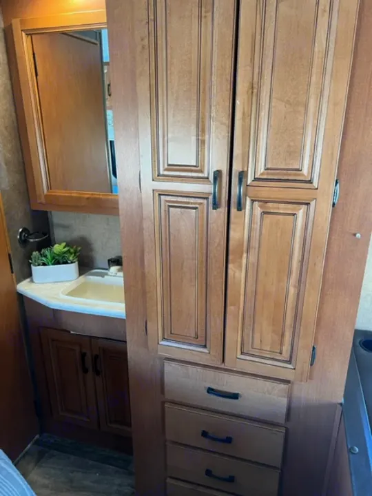 RV rental interior showcasing light wood cabinetry, various drawers, and a compact sink for efficient storage.. Forest River Sunseeker 2016