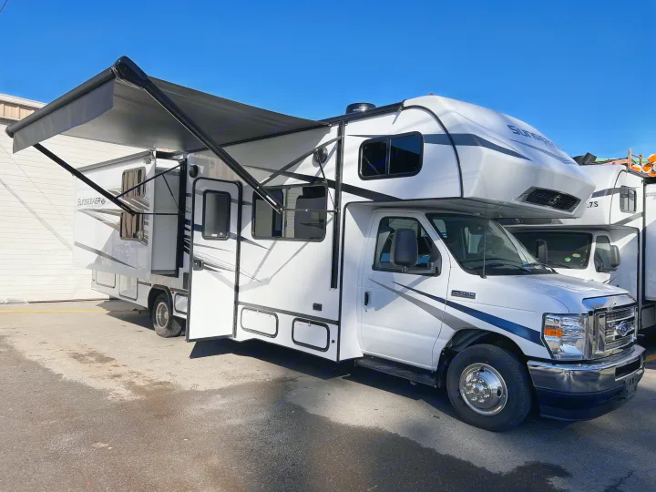 A pristine white Sunseeker RV rental (motorhome) with its awning extended and slide-out open, ready for travel.. Forest River Sunseeker 2024