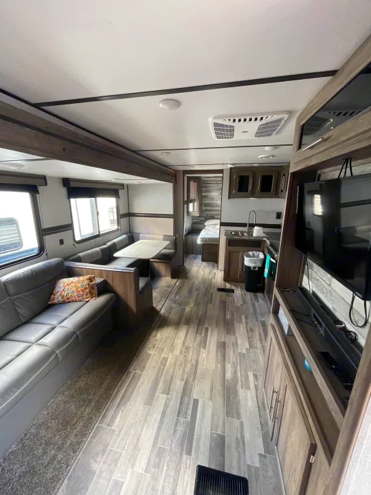 Spacious and modern RV rental interior featuring a living area, kitchen, dinette, and private bedroom.. Crossroads RV Zinger Lite 2021