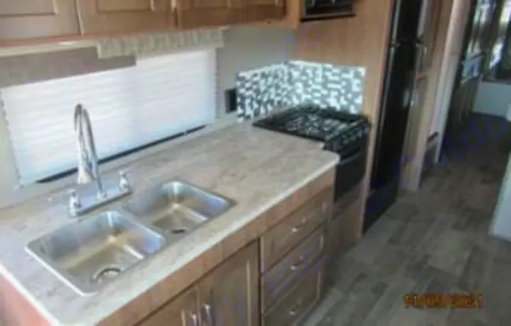 Modern RV rental kitchen interior featuring a double sink, stove, and ample counter space for your travel adventures.. Winnebago Intent 2018