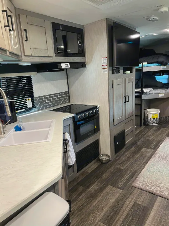 RV rental: Modern RV interior featuring a functional kitchen, bunk beds, and entertainment setup.. Heartland RVs Mallard 2021
