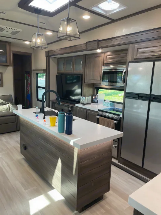 Bright, modern RV rental interior with a fully equipped kitchen, island, and comfortable living area.. Grand Design Solitude S-Class 2021