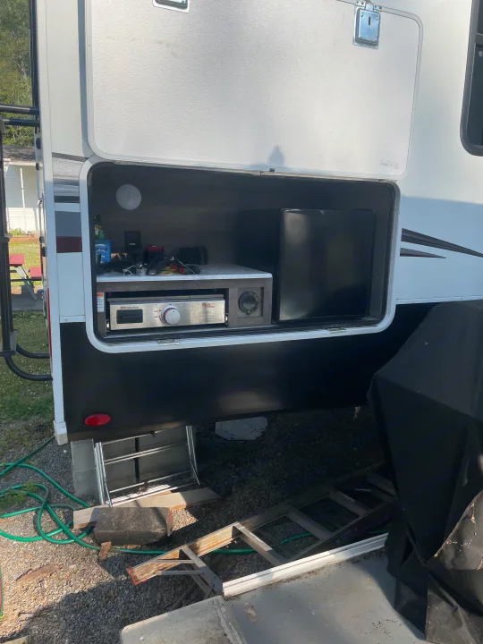This RV rental features a functional outdoor kitchen with a built-in griddle and mini-fridge.. Grand Design Solitude S-Class 2021
