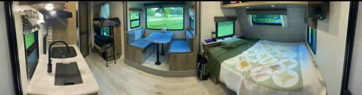 Spacious RV rental interior featuring a full kitchen, bunk beds, dining booth, and comfortable master bed for family travel.. Forest River Surveyor Legend 2023