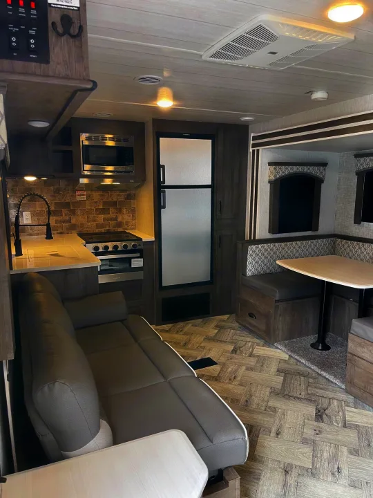 Spacious RV rental interior with a modern kitchen, comfortable sofa, and dinette. Perfect for your next road trip adventure.. Forest River Evo 2022