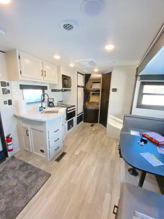 Modern RV rental interior with a fully equipped kitchen, comfortable dining area, and cozy bunk beds.. JAYFLIGHT 242BHSW-G 2023