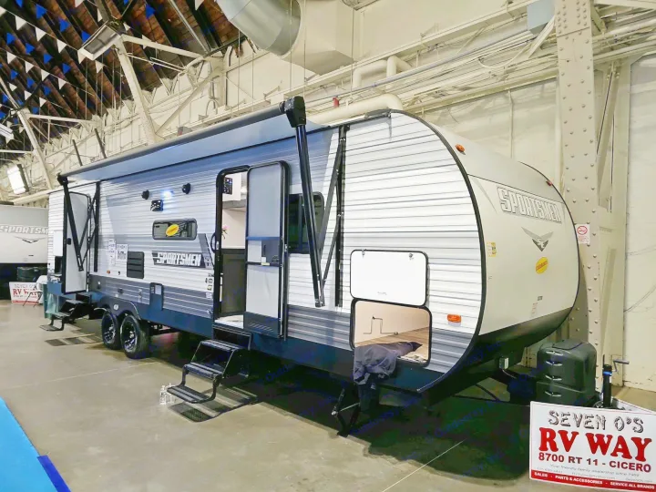 This modern Sportsmen travel trailer, ideal for an RV rental adventure, is showcased at a dealership, ready for your next road trip.. KZ 312 Bunk House 2022