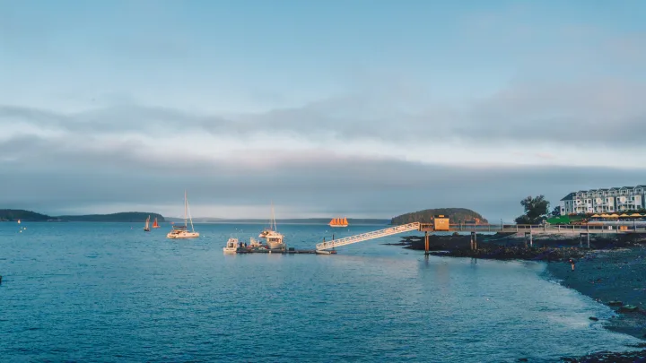 Twilight coastal harbor: boats, long pier, & waterfront resort. A scenic travel destination. Consider an RV rental trip!. Jayco Jay 2015