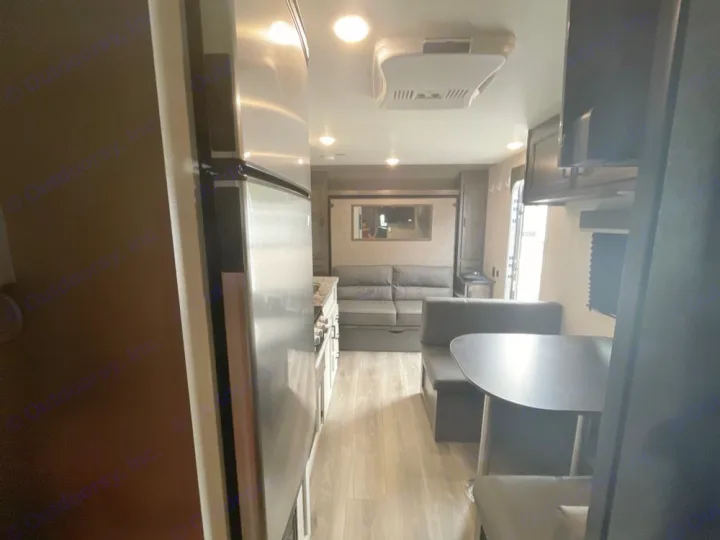 Inside this modern RV rental: a gleaming kitchen, comfortable living area with sofa, and a cozy dinette. Ready for travel!. Highland Ridge RV Open Range 2021
