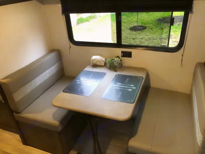 Cozy RV rental dinette featuring comfortable benches, a table with placemats, and a large window view, ideal for travel.. Forest River Coachmen RV Clipper Ultra-Lite 17BH 2022