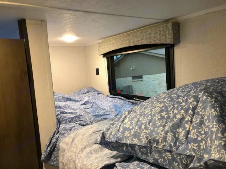 Cozy RV rental bedroom with blue floral bedding and emergency exit window.. Forest River Coachmen RV Clipper Ultra-Lite 17BH 2022