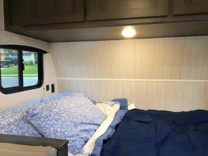Cozy RV rental bedroom showing a comfortable bed, window, and overhead cabinets. Ready for your travels!. Forest River Coachmen RV Clipper Ultra-Lite 17BH 2022